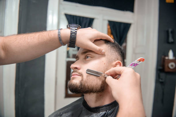 istock Barber is cutting and making shape of customers beard 1316211035