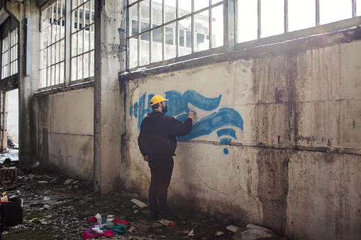 Street artist is spraying graffiti