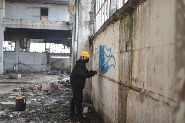 istock Man is painting graffiti on the wall 1316211772