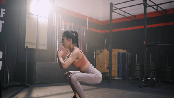 exercício de mulher asiática esportiva fazendo agachamento musculação de peso corporal construindo músculos e queimaduras de gordura cardio, estilo de vida saudável na academia fitness - crouching barbell weightlifting weight training - fotografias e filmes do acervo