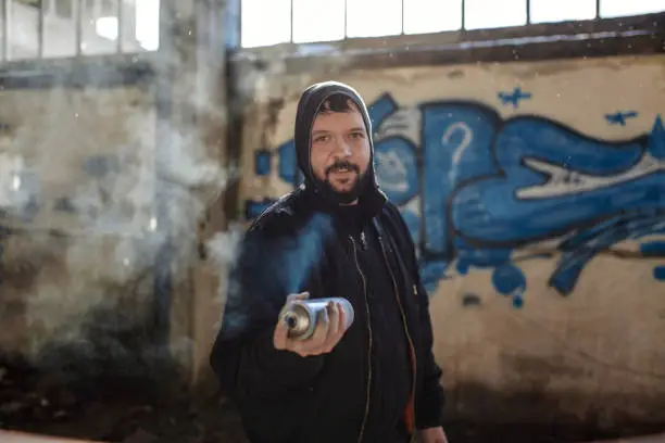 Photo of Street artist is facing camera with spray can in his hand