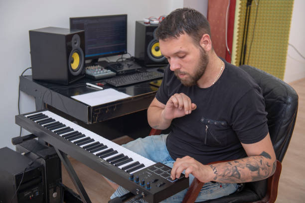 istock Man is playing piano in music studio 1316211920