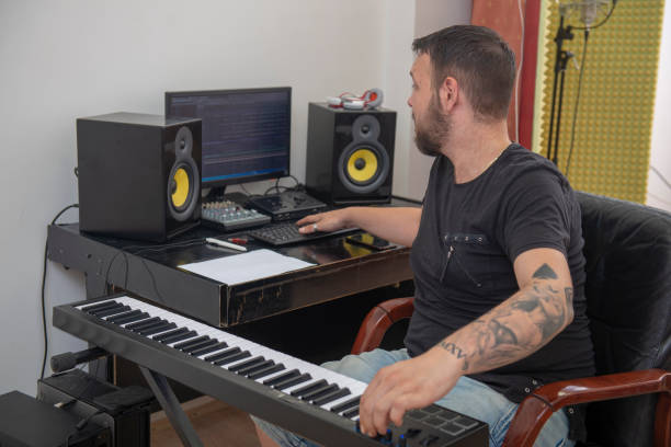 istock Man is playing piano in music studio 1316211934
