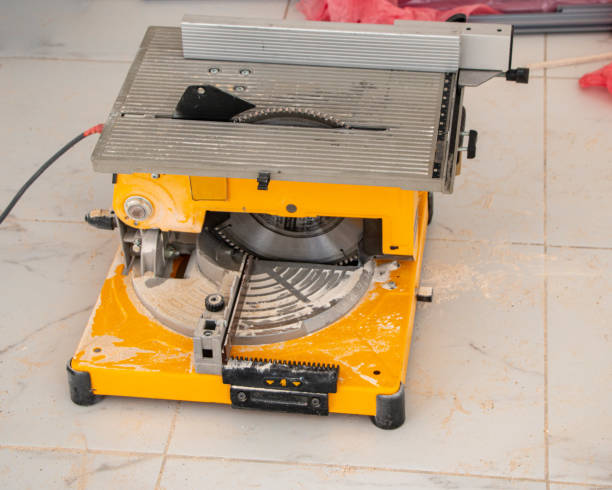 male hands of  construction worker sawing and cutting parts of  electric miter saw from  wooden board. wood board cutting process with blade rotation and dusty cloud electric miter saw male hands of a construction worker sawing and cutting parts of an electric miter saw from a wooden board. wood board cutting process with blade rotation and dusty cloud electric miter saw miter saw stock pictures, royalty-free photos & images