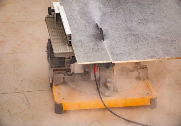 male hands of  construction worker sawing and cutting parts of  electric miter saw from  wooden board. wood board cutting process with blade rotation and dusty cloud electric miter saw male hands of a construction worker sawing and cutting parts of an electric miter saw from a wooden board. wood board cutting process with blade rotation and dusty cloud electric miter saw miter saw stock pictures, royalty-free photos & images