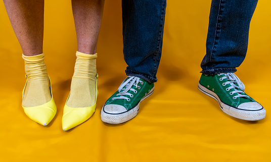 male and female legs with shoes in the style of the 50s on a colored background