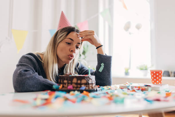 istock Sad woman blowing candles alone 1316219263