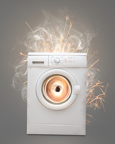 A washing machine violently spinning with smoke and sparks. Isolated on a neutral background.
