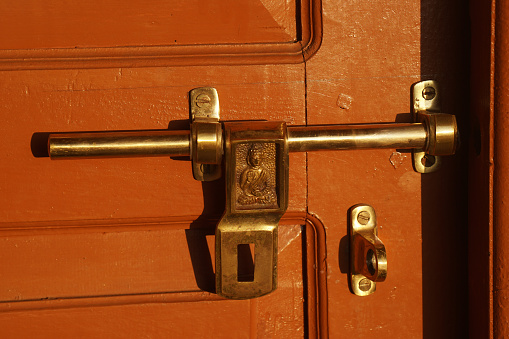 Closeup Golden Door bolt \nBuddha print - Religion and belief in preventing evil