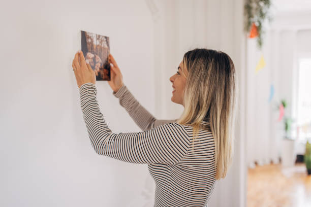 istock Woman decorating her wall with photograph 1316222249