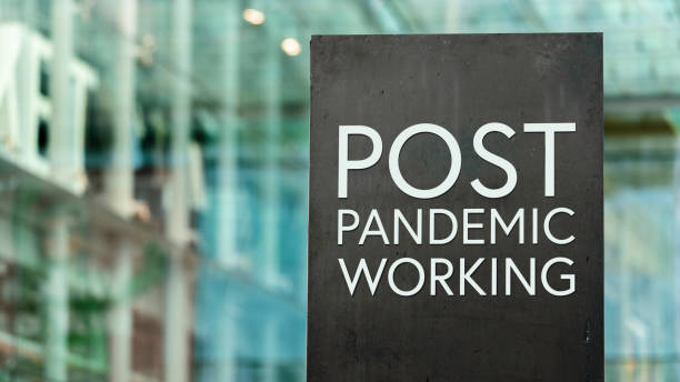 istock Post Pandemic Working sign in front of a modern office building 1316222446