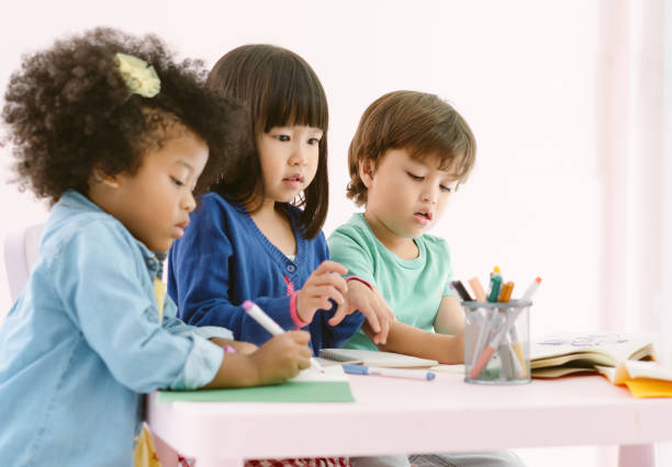 grupo de diversidad niños dibujando y pintando con crayón junto con diversión en la clase de arte en el jardín de infantes. preescolar internacional, concepto de educación. - preschool fotografías e imágenes de stock