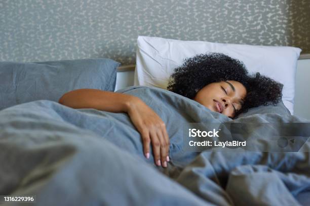 Shot Of A Young Woman Sleeping In Her Bed At Home Stock Photo - Download Image Now - Sleeping, Bed - Furniture, Cozy