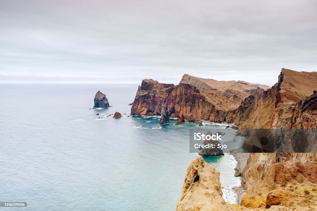 Ponta de São Lourenço peninsula landscape at Madeira island during an overcast summer day View over the cliffs at Miradouro da Ponta do Rosto on the Ponta de São Lourenço peninsula at the eastern side of Madeira island during an overcast summer day. The cliffs are rising up from the Atlantic Ocean. Atlantic Islands Stock Photo