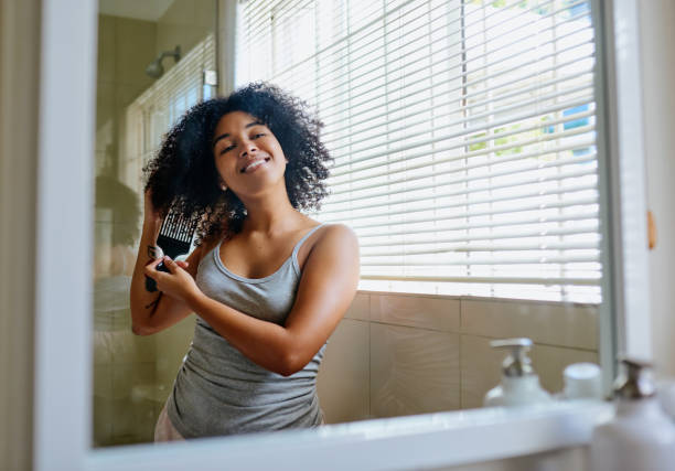 Shot of a beautiful young woman using an afro comb on her hair at home There's no such thing as a bad hair day! combing photos stock pictures, royalty-free photos & images