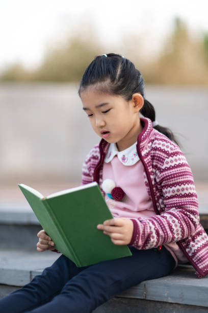 istock Little Girl Reading Book 1316229568