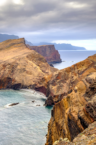 View over the cliffs at Ponta de São Lourenço peninsula at the eastern side of Madeira island during an overcast summer day. The cliffs are rising up from the Atlantic Ocean.