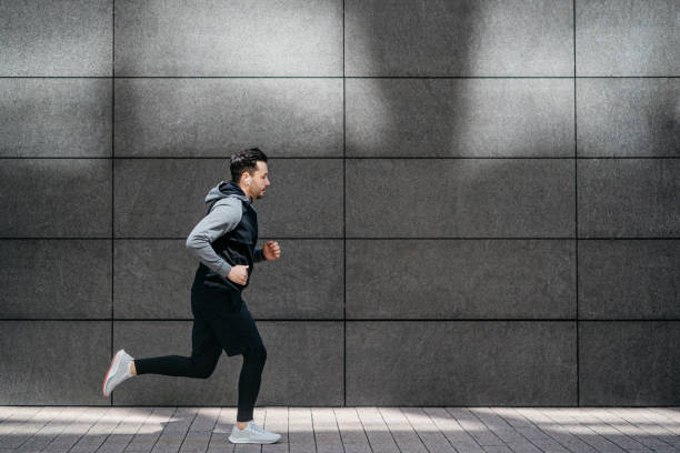 istock Athletic man jogging in front of gray modern wall 1316230526