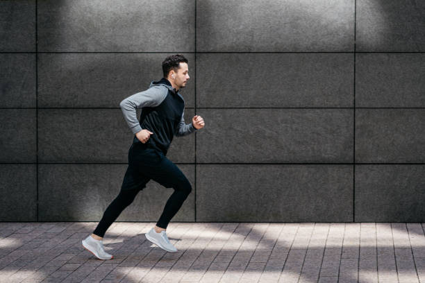 istock Athletic man running in front of gray modern wall 1316230617