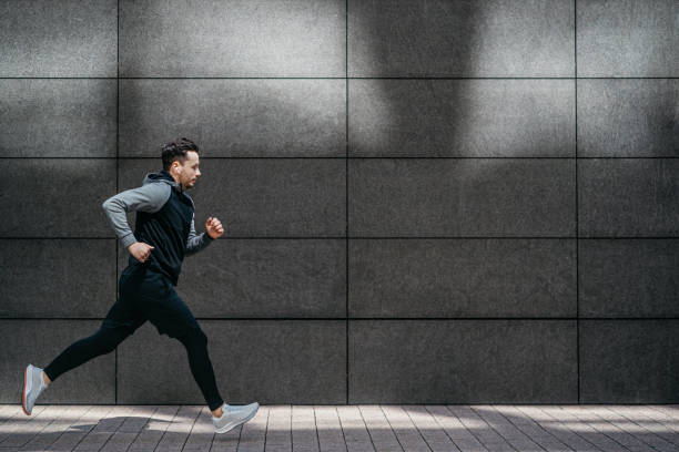 istock Athletic man running in front of gray modern wall 1316230695