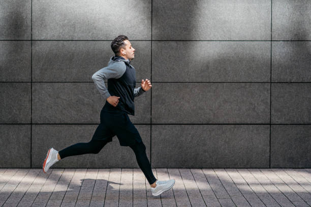 istock Athletic man running in front of gray modern wall 1316230791