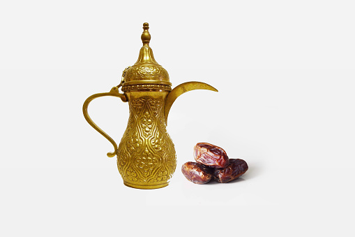 The Dallah ( Arabic coffee pot ) with Saudi dates on white backgroundز Eid al-Fitr