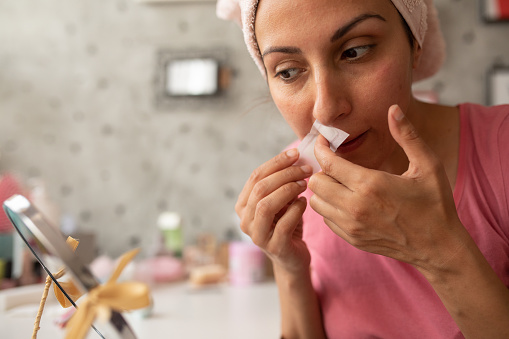 Woman preparing to get rid of unwanted hair on her upper lip at home