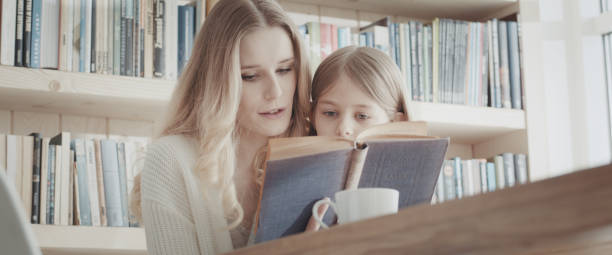 istock Caring mother reading book with her little daughter 1316235369