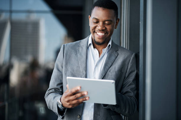 istock Shot of a handsome young businessman standing alone outside and using a digital tablet during the day 1316235439