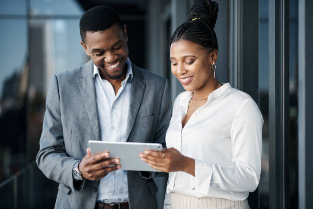 istock Shot of two businesspeople standing outside together and having a discussion while using a digital tablet 1316235441