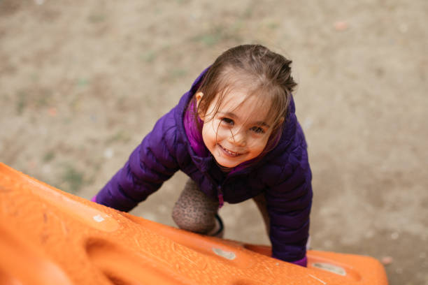 istock Small girl enjoying climbing outdoors at playground 1316235690