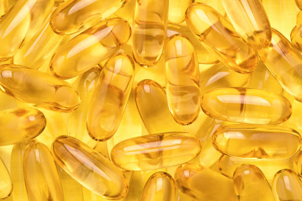 istock Fish oil capsules, Omega 3 softgels on yellow background. 1316235780