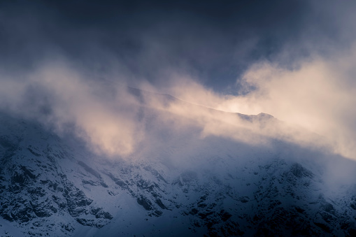 Dramatic cloudscape over High Tatras, Poland. The clouds are covering rocky ridge where the trail to Świnica Peak is. Selective focus on the rocks, blurred background.