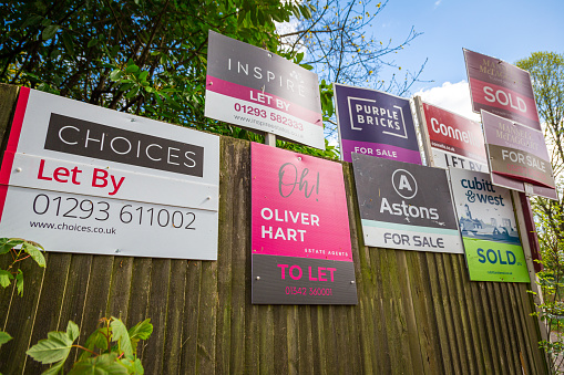 Crawley, UK - 4 May, 2021: color image depicting a collection of different property for sale and sold signs in a residential district in the town of Crawley, UK.