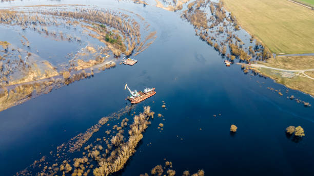 istock Dredger is working to deepen the fairway on the river. Cleaning and deepening by a dredger on the river. Sunset on the river. Industrial concept. 1316239679