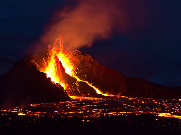 Stunning view of volcanic eruption in Geldingadalir valley near Fagradalsfjall mountain, Grindavík, Reykjanes, Iceland with long exposure of lava ejection at night. stock photo