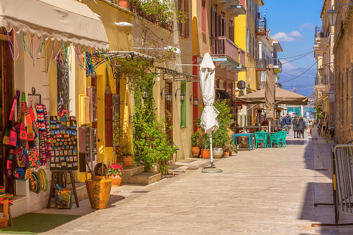 Nafplio, Greece - March 30, 2019: Old town street panorama with restaurants in Nafplion, Peloponnese