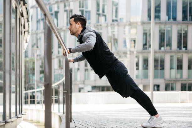 istock Man doing puh-ups on a railing in an urban surrounding 1316241670