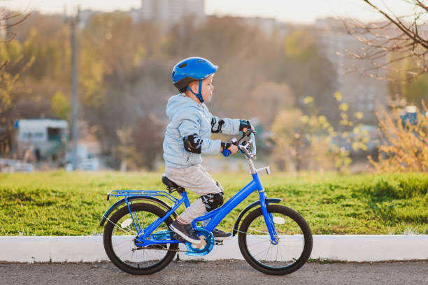 istock Little kid in helmet rides a bicycle on a sunny day 1316242914