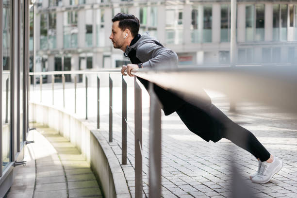 istock Man doing puh-ups on a railing in an urban surrounding 1316242956