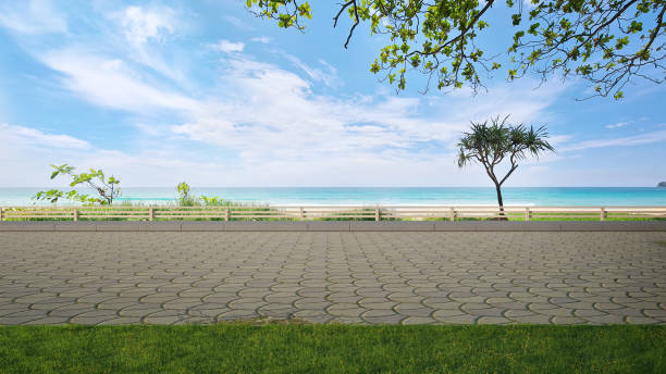 Cobblestone road floor and big garden with sea view. 3d illustration of empty green grass lawn. cobblestone stock pictures, royalty-free photos & images