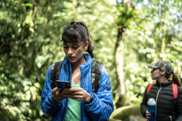 istock Women using smartphone in a forest during hiking 1316243281