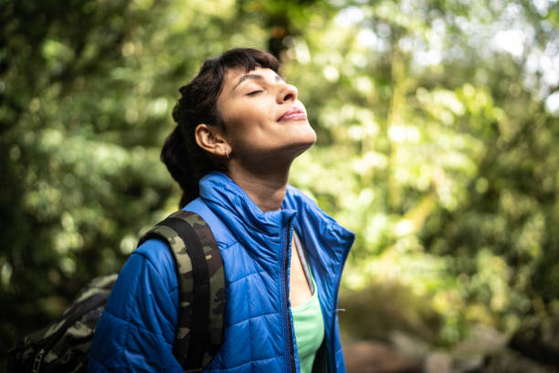 giovane donna che respira aria pura in una foresta - hiking adventure outdoor pursuit backpacker foto e immagini stock