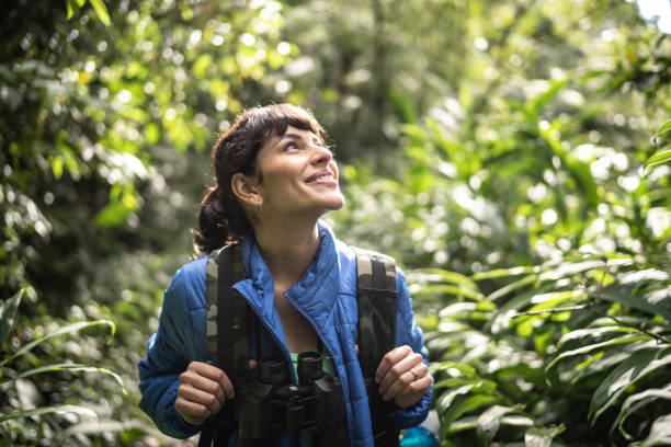 glückliche frau sieht aroung beim wandern in einem wald - looking around stock-fotos und bilder