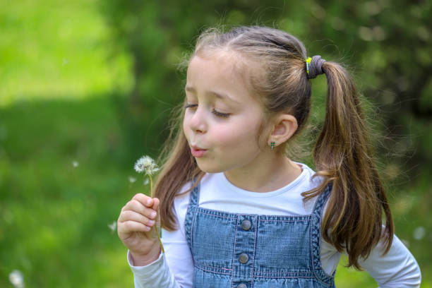 istock Small child blowing a dandelion 1316245627