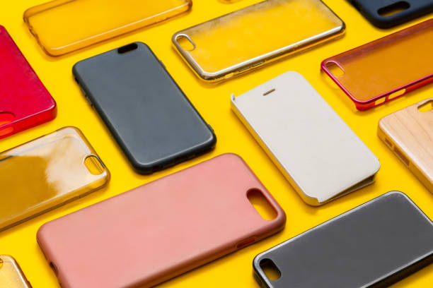 istock Pile of multicolored plastic back covers for mobile phone. Choice of smart phone protector accessories on yellow background. A lot of silicone phone backs or skins next to each other 1316245636