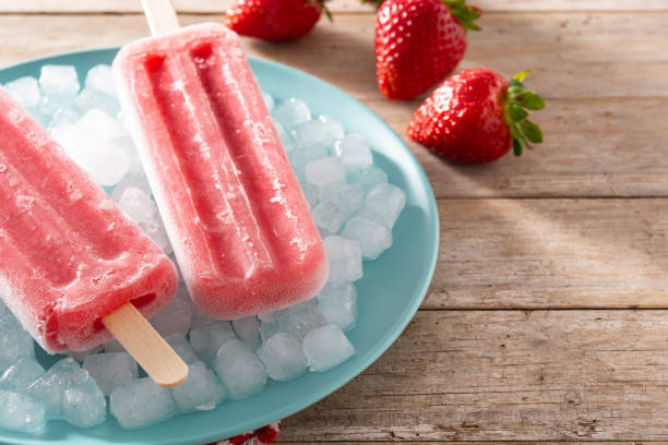 istock Strawberry popsicles on wooden table 1316248002