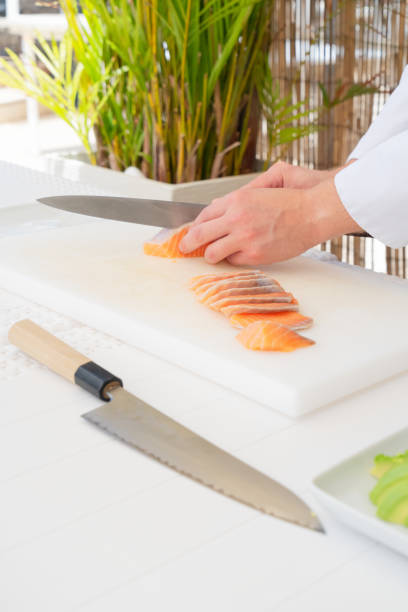 istock Male chef in uniform cutting fresh salmon for sashimi 1316254463