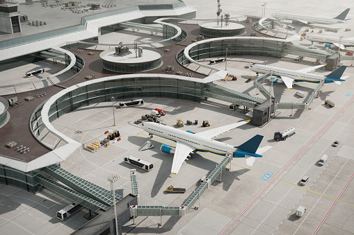 Aerial view of aircrafts at the parking lot. High-angle view of commercial airplanes parked near airport terminals.