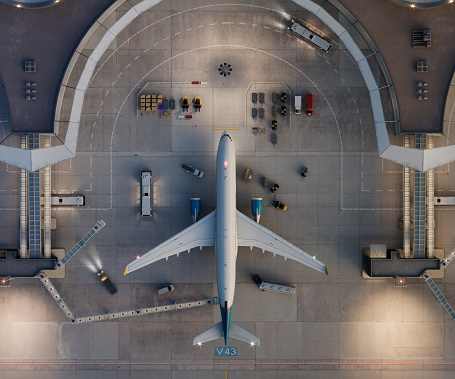 Directly above view of a passenger plane at airport terminal. 3D drone view of  airport terminal with parked aircraft.